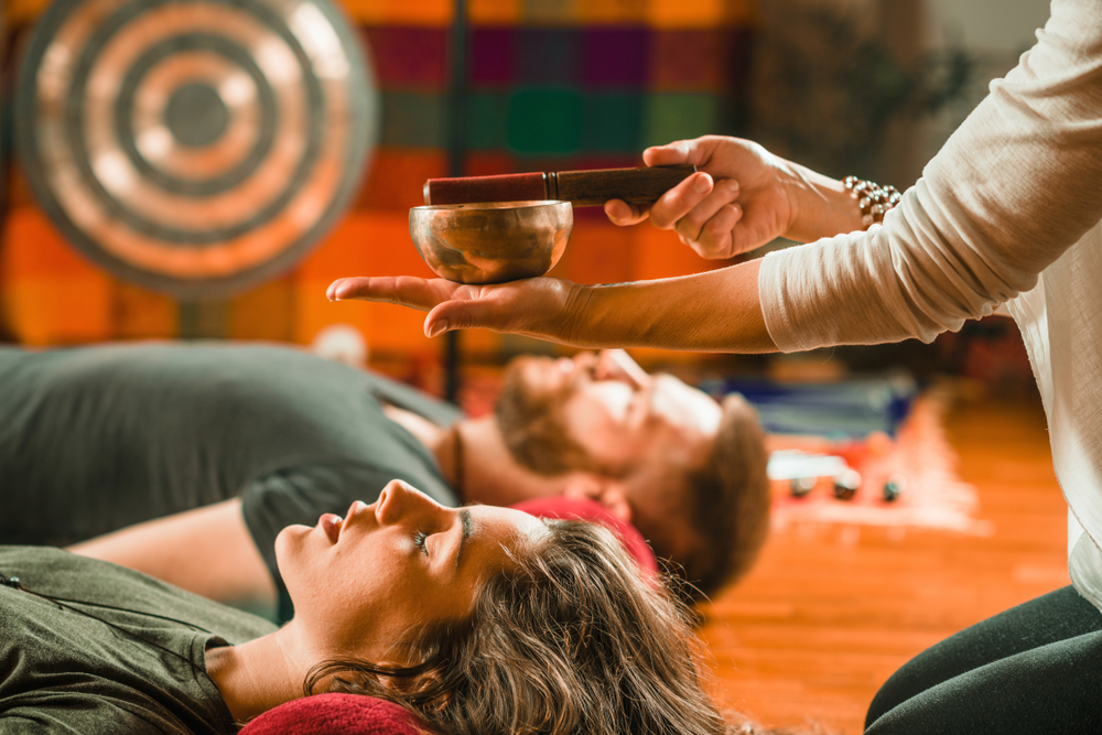 Holistic wellness Participants relax to vibrations of a singing bowl during Sound Healing Class