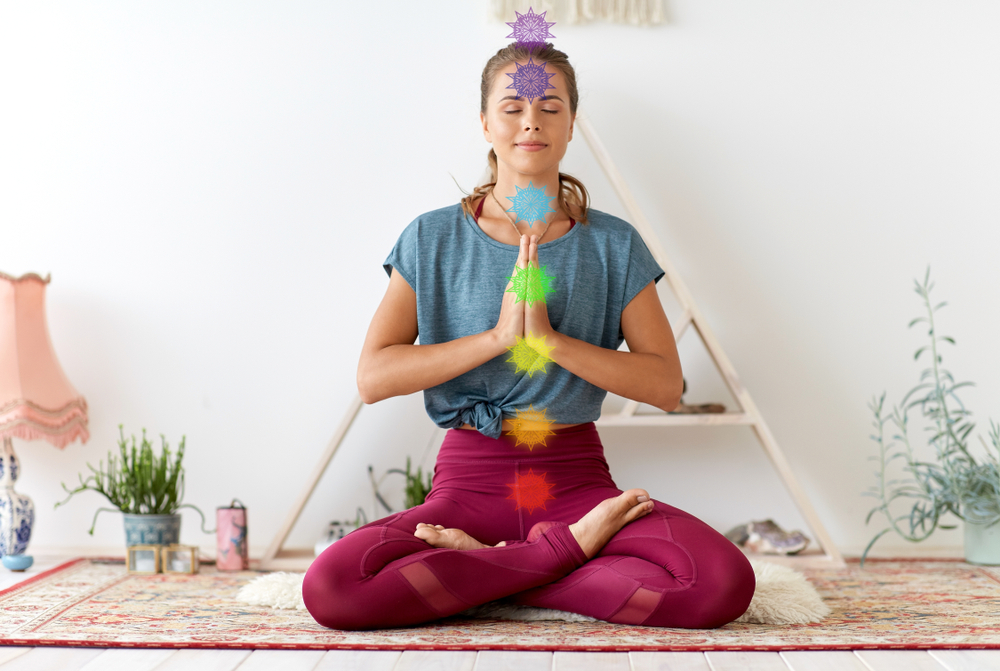 Women uses mindful practices to balance and heal her seven main chakras during Chakra Healing Class